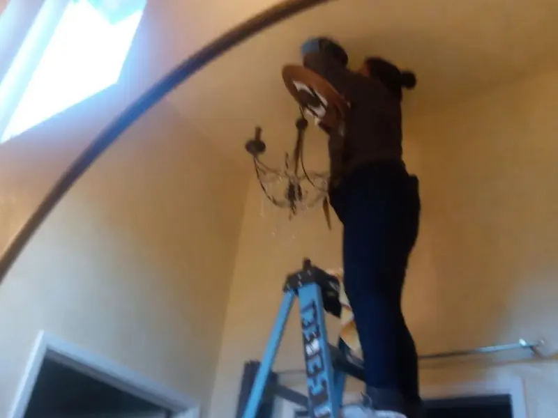 Electrician installing a chandelier in a Silver Springs residence